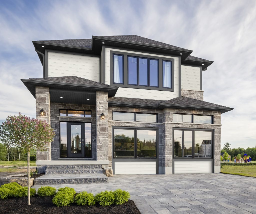 Home exterior featuring PVC composite siding and manufactured stone veneer for lasting summer curb appeal.