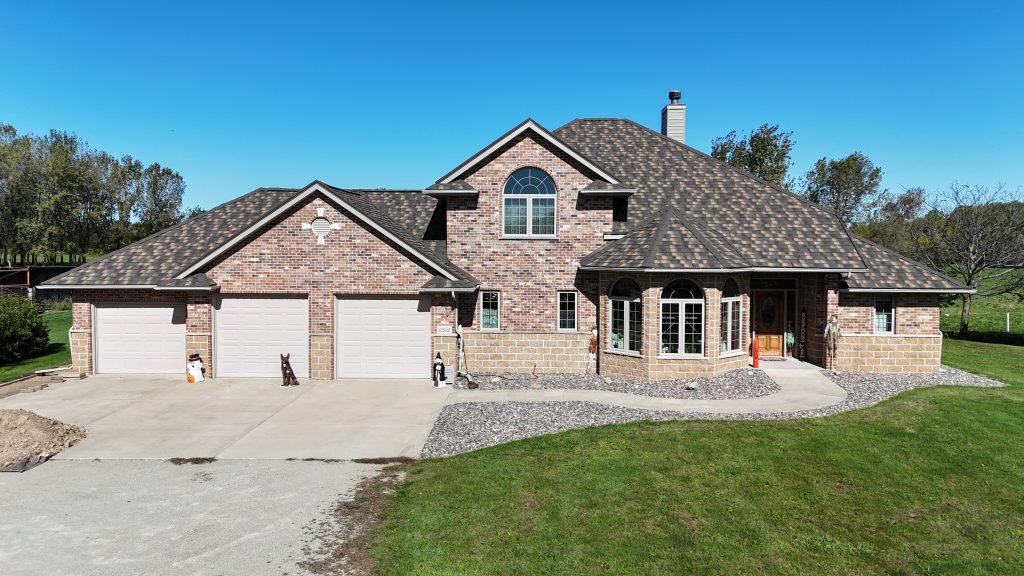 Midwest home exterior featuring a durable mix of traditional brick veneer and neutral manufactured stone accents.