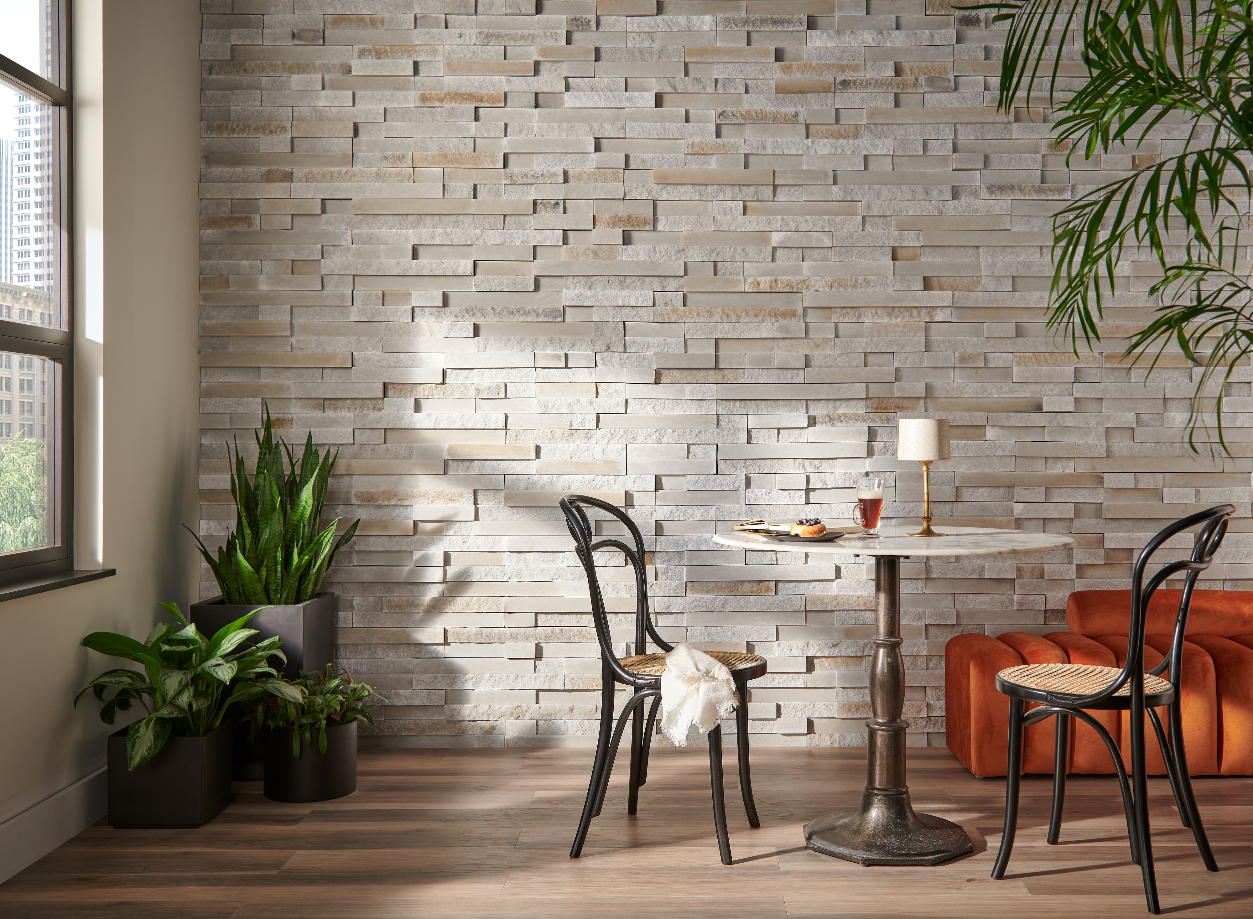 Indoor dining area with stone accent wall and plants.