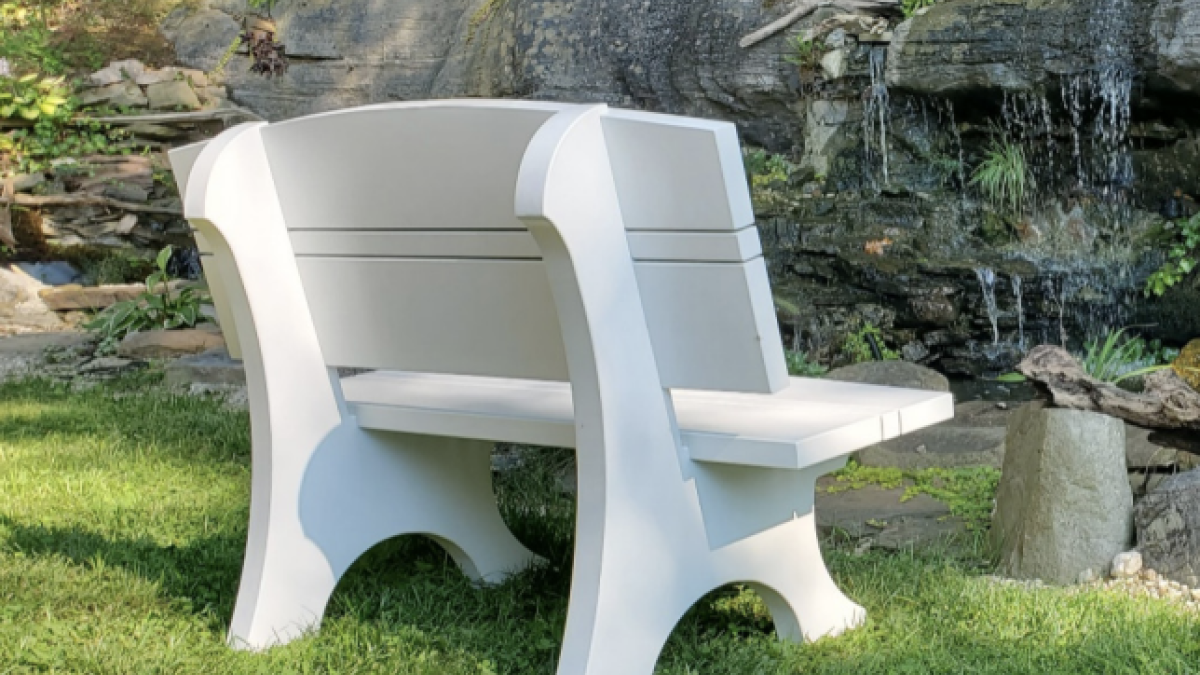 A bench made with Royal trim near a pond