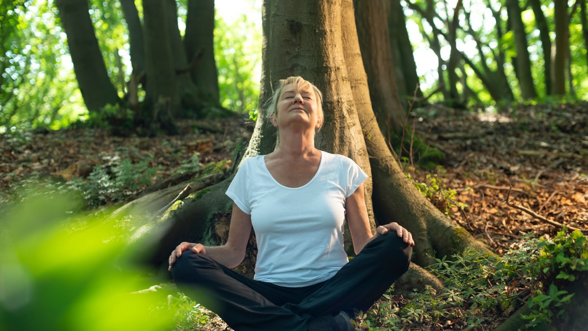 woman sitting in the woods cross legged